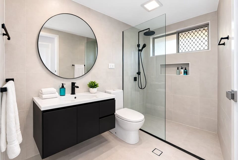 Modern bathroom with walk-in shower and fresh towels provided.