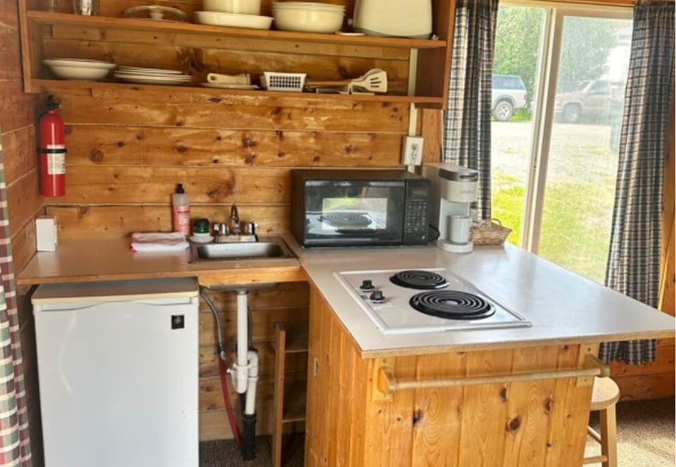 Kitchenette with a stovetop, microwave, mini fridge, Keurig coffee maker. 