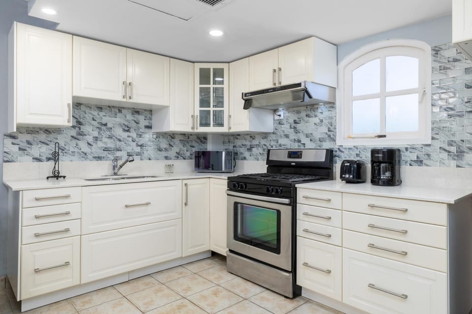 The kitchen offers plenty of cabinet space and all the essentials for home-cooked meals—microwave, stove, oven, fridge, coffee maker, blender, toaster, cookware, and more. Enjoy the ease of dining in!