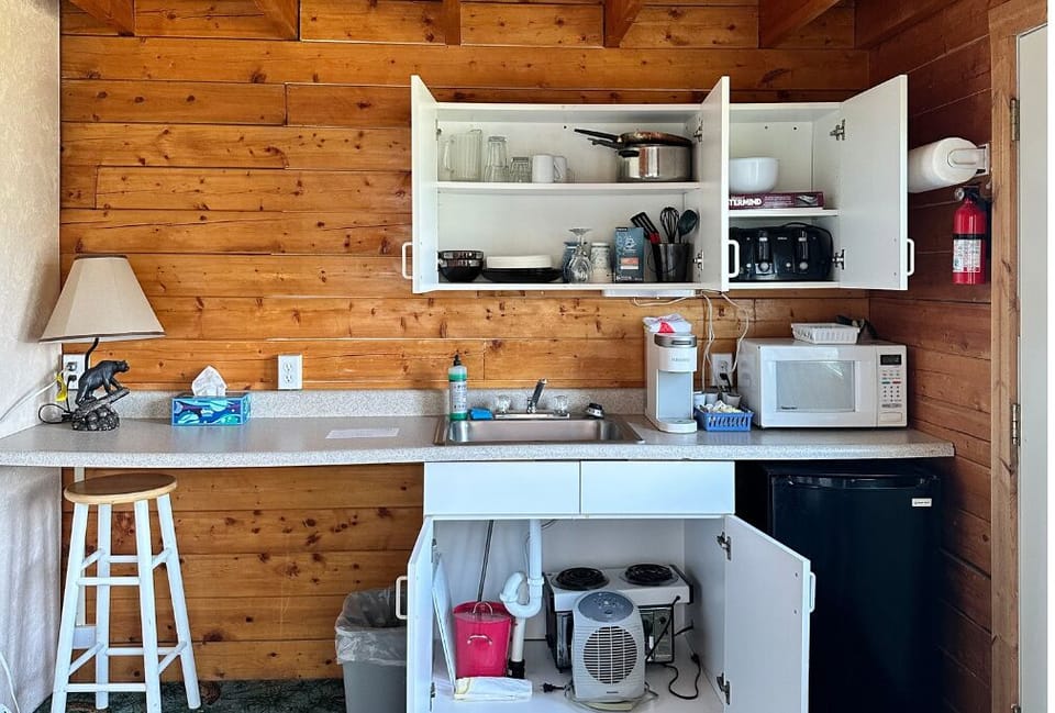 Kitchenette features a microwave, a Keurig coffee maker, cookware, and dishes. 