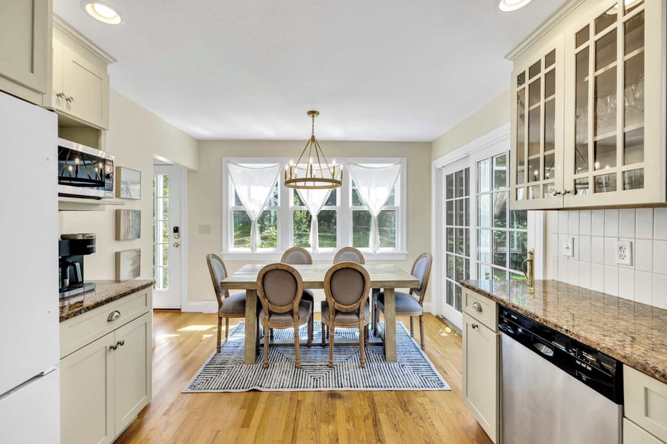 Large windows and French doors bathe the dining space in sunshine and offer views of the peaceful backyard.