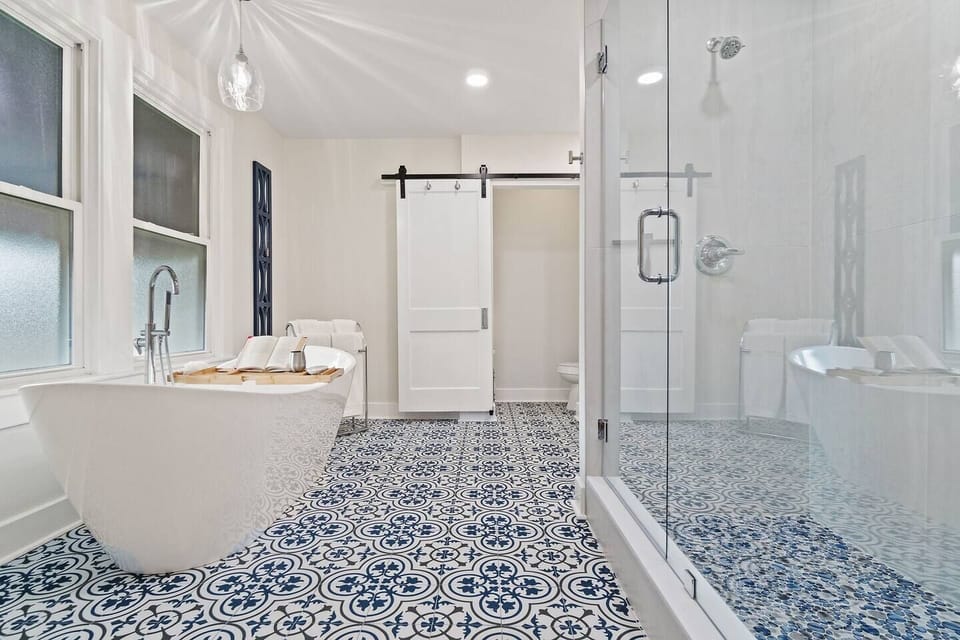Luxury master bathroom features double shower, soaking tub, and designer tile for spa-like relaxation in downtown Pensacola.