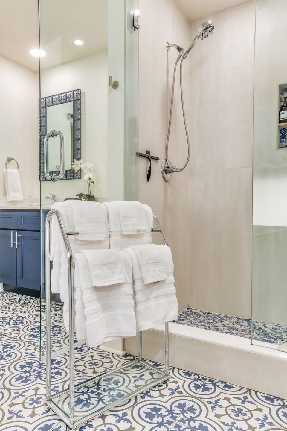 Modern walk-in shower with designer tile, premium fixtures, and plush towels provided for family convenience.