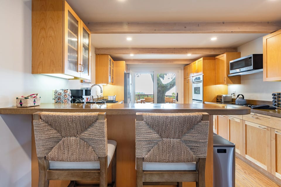 Spacious kitchen with a breakfast bar, modern appliances, and patio access.