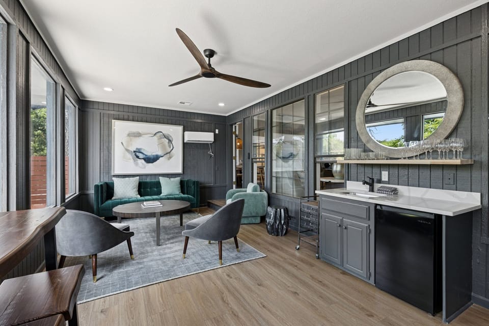 A stylish secondary lounge with moody tones, plush seating, and a fully stocked bar area for relaxing or entertaining.

