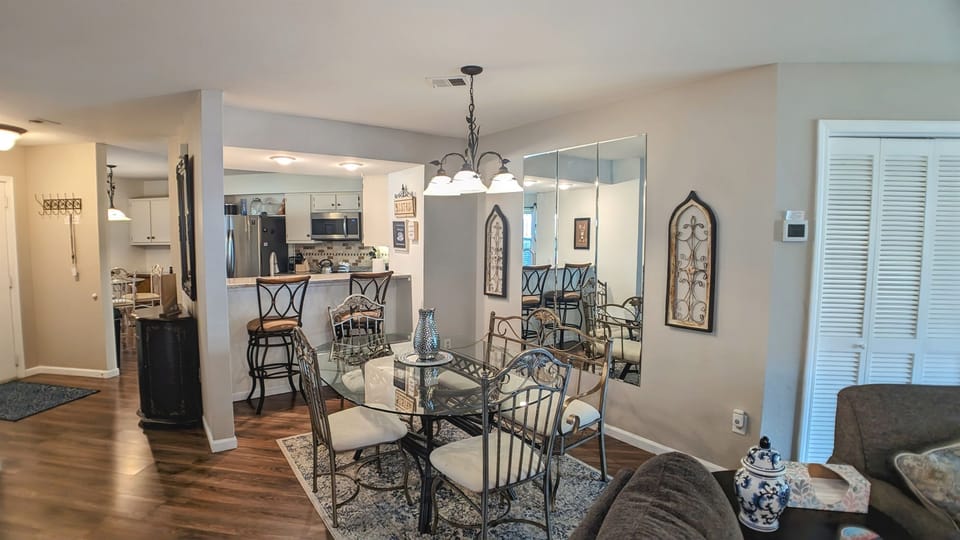 Dining area with seating for 5 at the table and 2 seats at bar