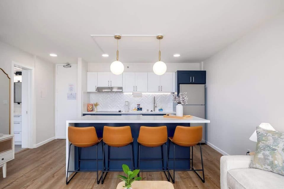This sleek and modern kitchen features a spacious island with 4 chairs, perfect for casual dining or entertaining.