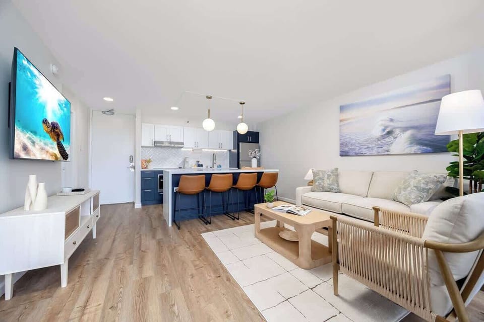 This spacious open-concept living area combines a comfortable living area with a modern kitchen and breakfast bar, perfect for relaxation and entertaining.