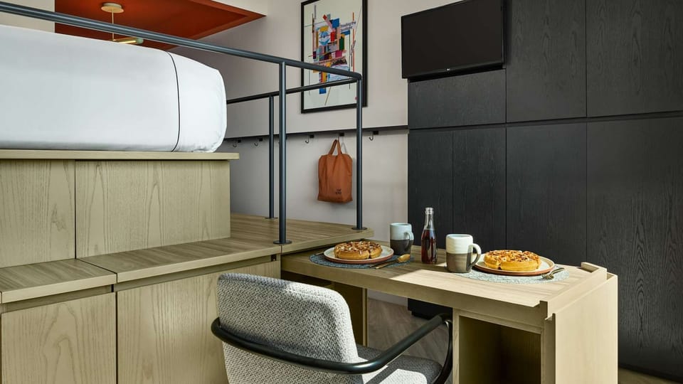 Small table with plates and drinks tucked neatly under the bed