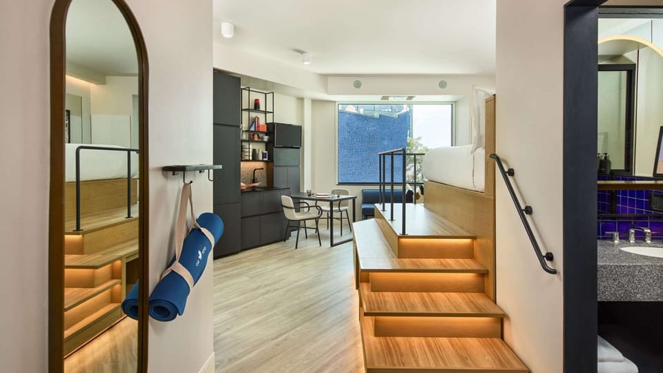 Open layout with steps to bed, full kitchen, and window seating