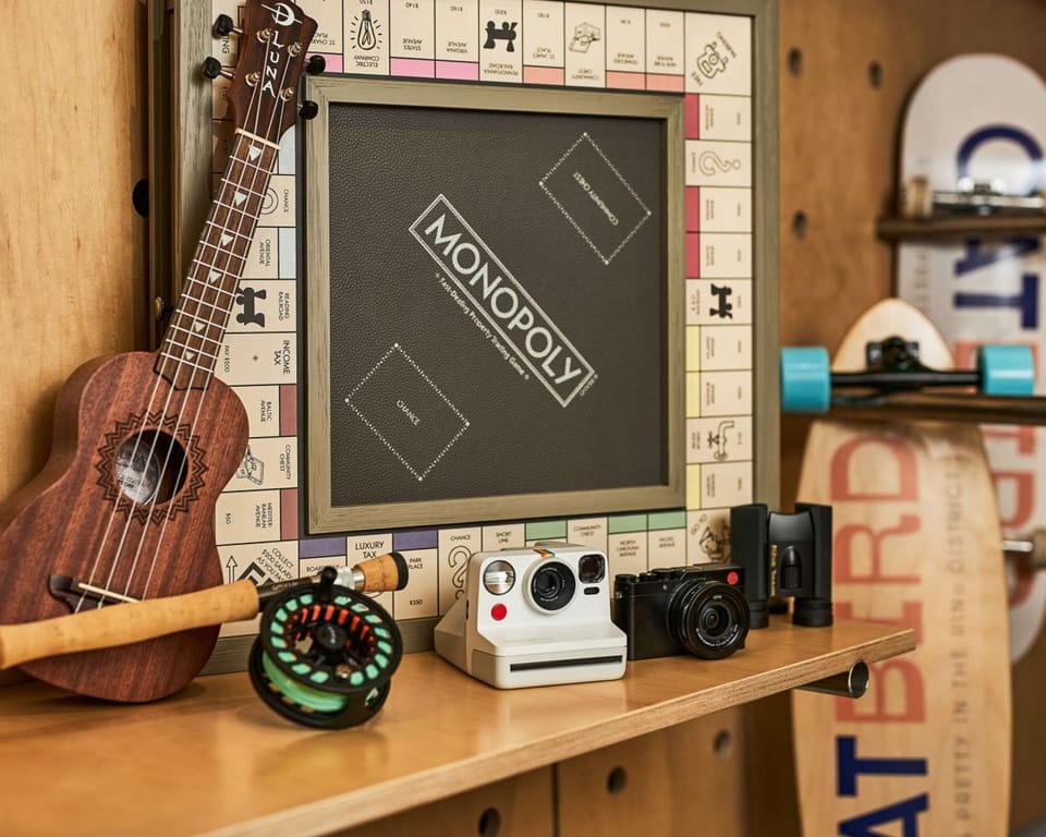 Playroom with Monopoly board, cameras, ukulele, and skateboards