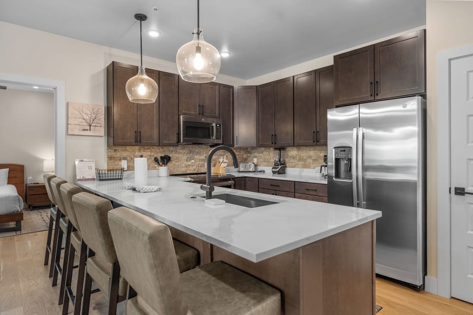 Your fully equipped kitchen invites culinary adventures with sleek quartz counters, stainless appliances, and a breakfast bar perfect for morning coffee.