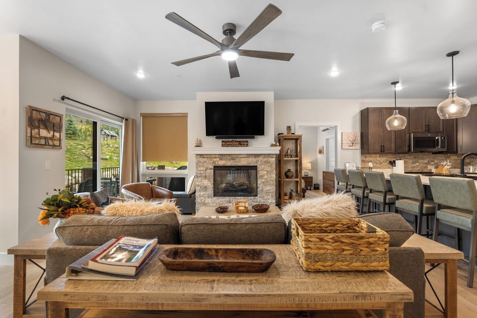 Relax in your stylish open-concept space where warm fireplace meets modern kitchen, perfect for gathering with loved ones.