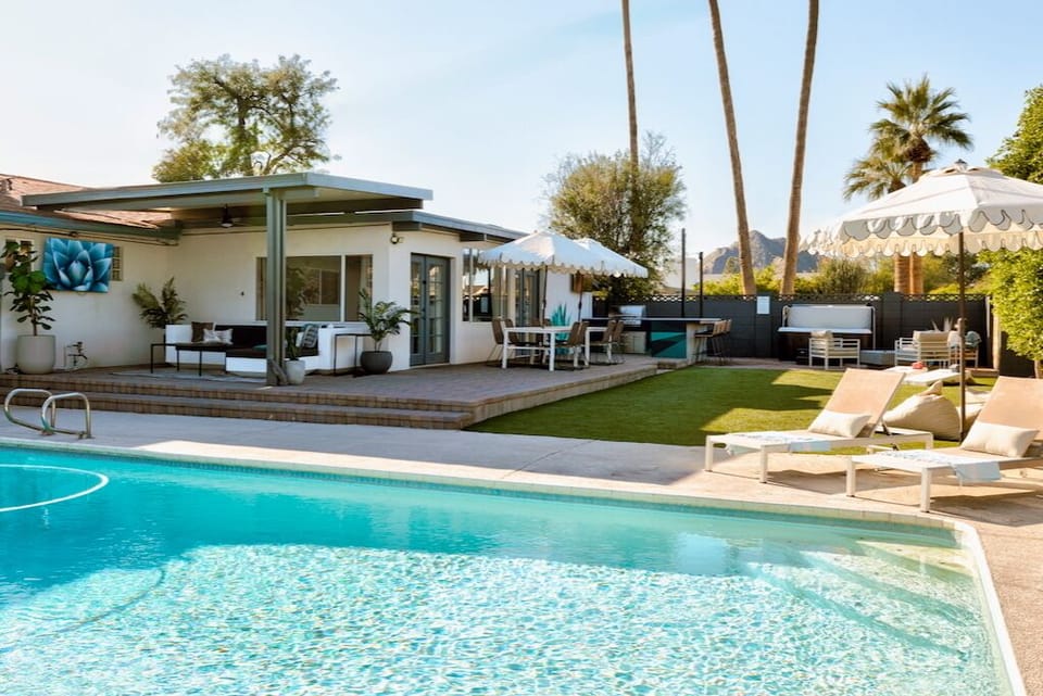 Resort-style backyard offers heated pool, outdoor living, hot tub, kitchen