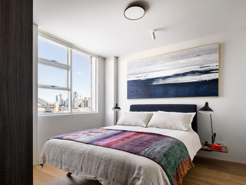 Queen size bed with views of Sydney Harbour bridge from window