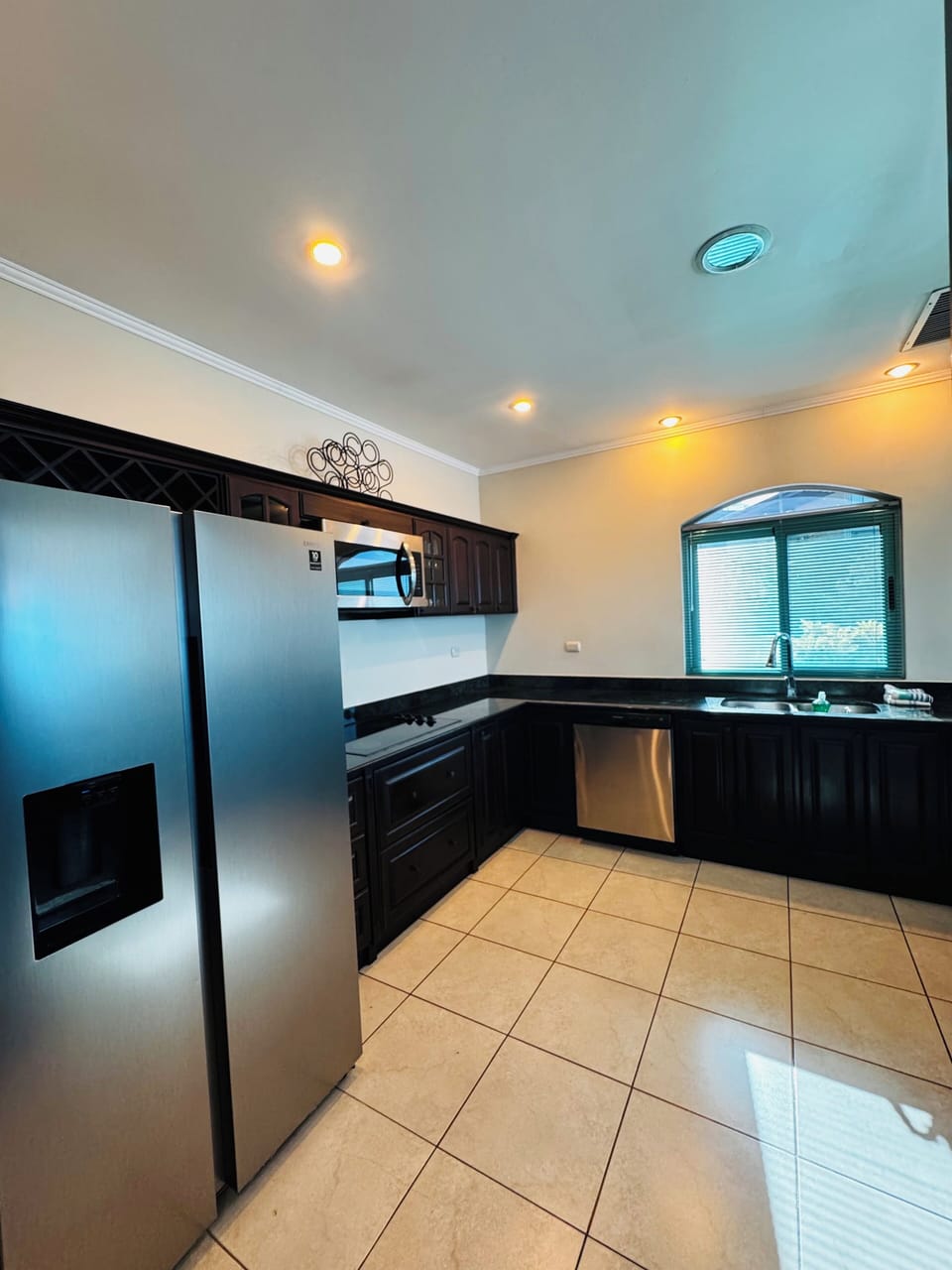 Kitchen with fridge, stove next to fridge, dishwasher, hot water sink