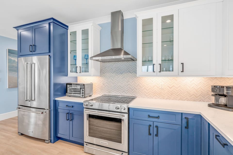 Cook in style with this fully equipped gourmet kitchen featuring custom cabinetry, premium appliances, and a panoramic view of the Gulf.