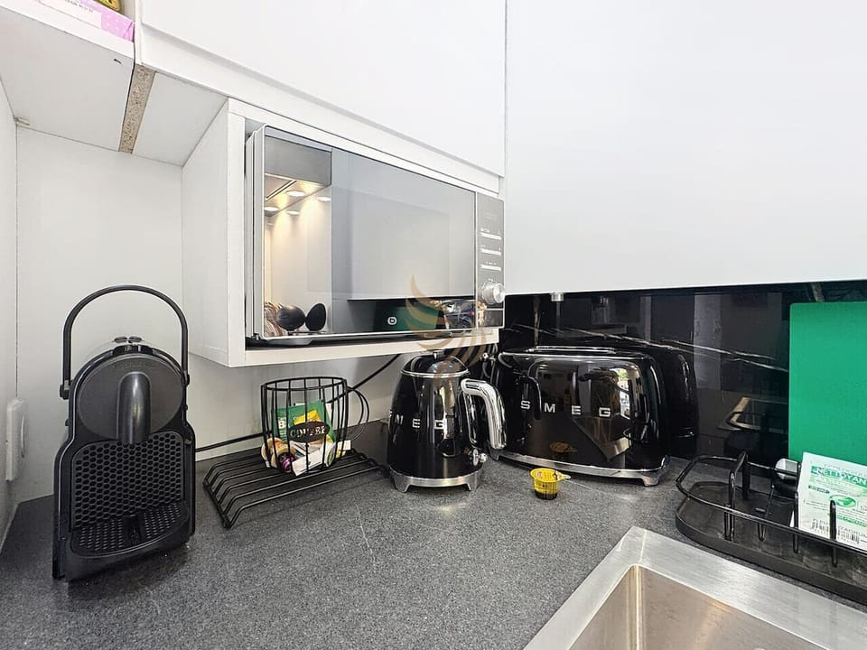 Cuisine bien équipée avec électroménagers modernes et plan de travail fonctionnel.