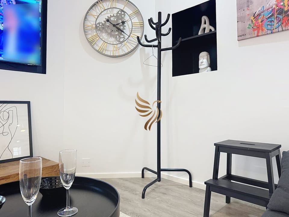 Espace salon, avec sa table basse design, porte-manteau et décoration contemporaine ?