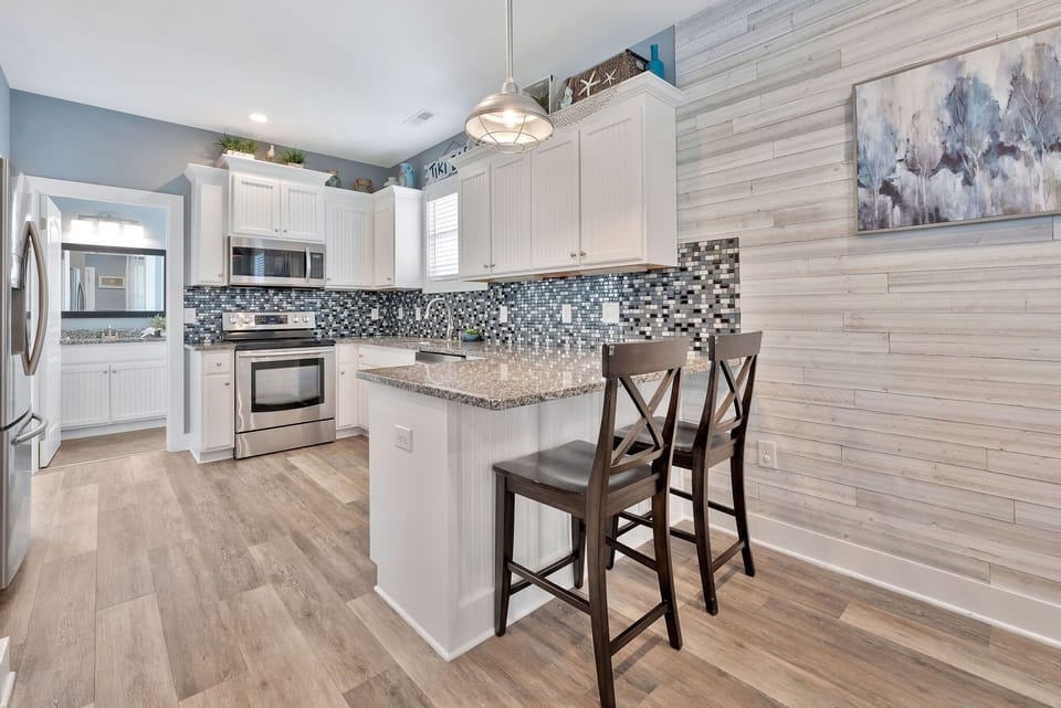 Grab a seat at the island for coffee, cocktails, or conversation—this bright and beachy kitchen is the heart of the home.