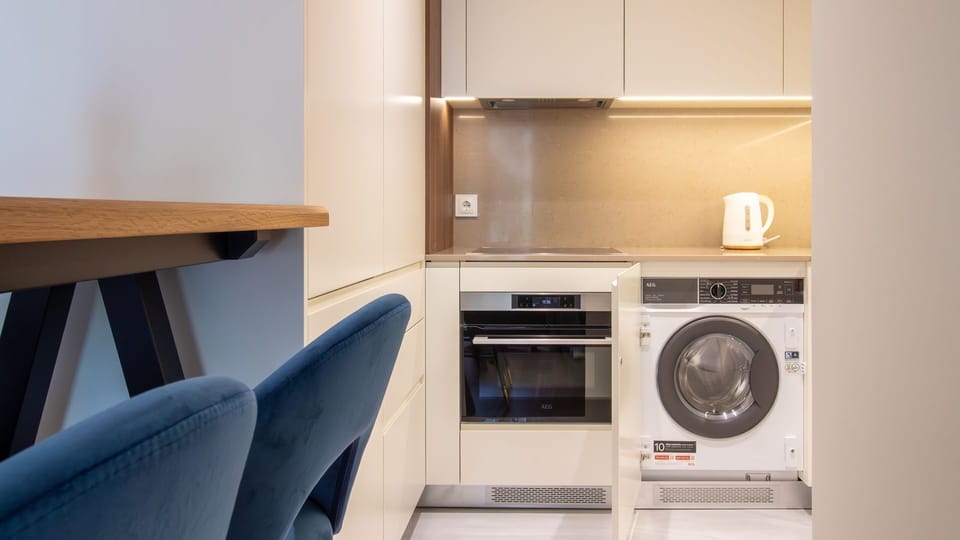 Convenient in-unit washer alongside a complete cooking setup for maximum comfort. #TravelEase #LaundryOnTheGo #FullyEquippedStay #ConvenientLiving