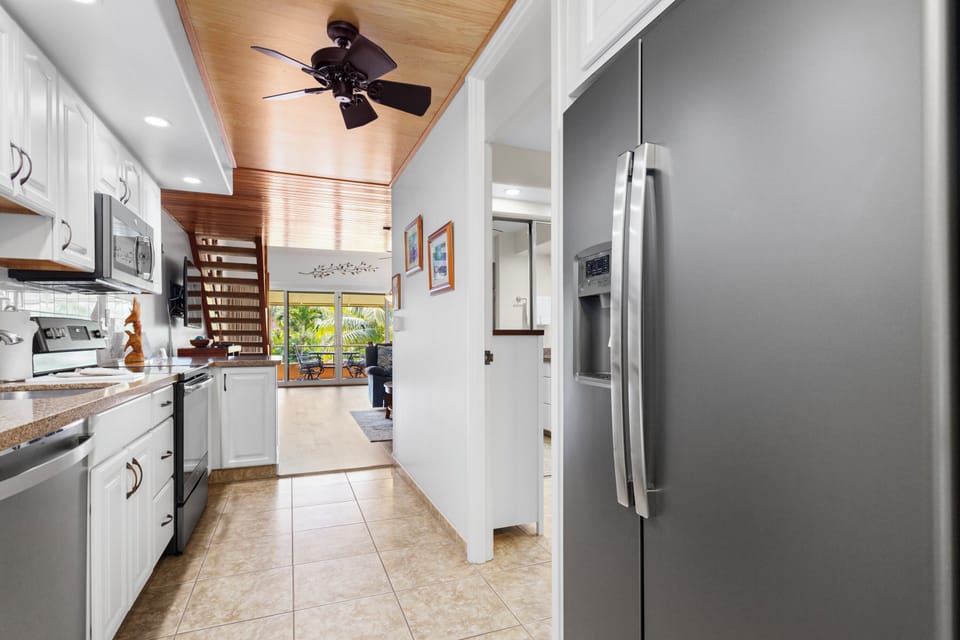 Your bright galley kitchen offers full-sized appliances and a stunning wood-paneled vaulted ceiling that draws the eye to the lush outdoor space beyond.