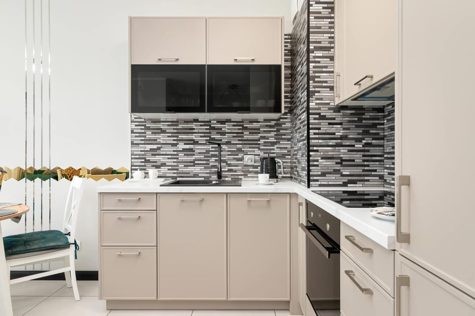 The kitchen with contrasting mosaic tiles and full equipment makes it easy to cook homemade meals comfortably.