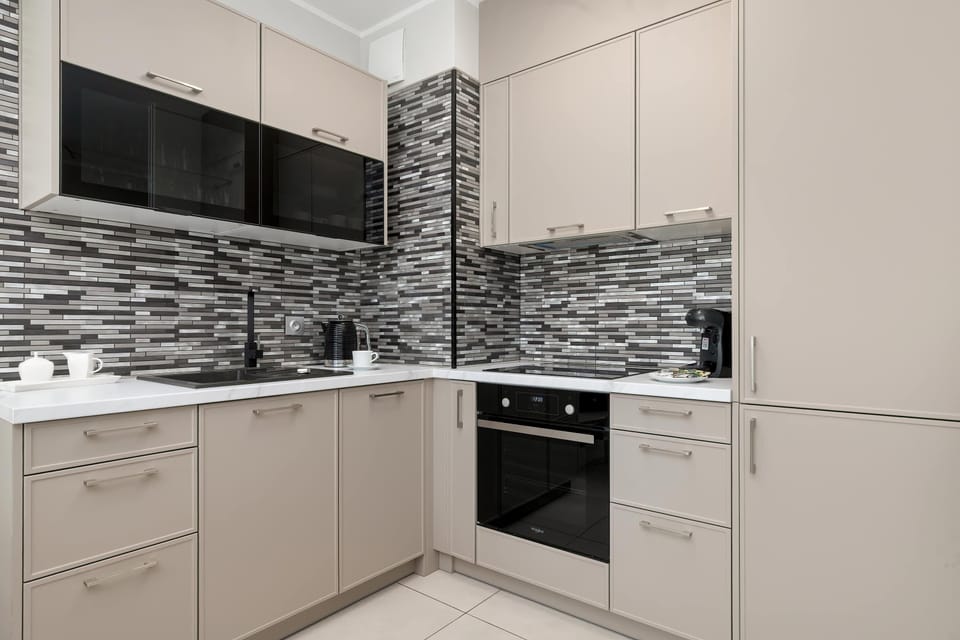 The spacious kitchen with a built-in oven and striking mosaic backsplash combines functionality with modern style.