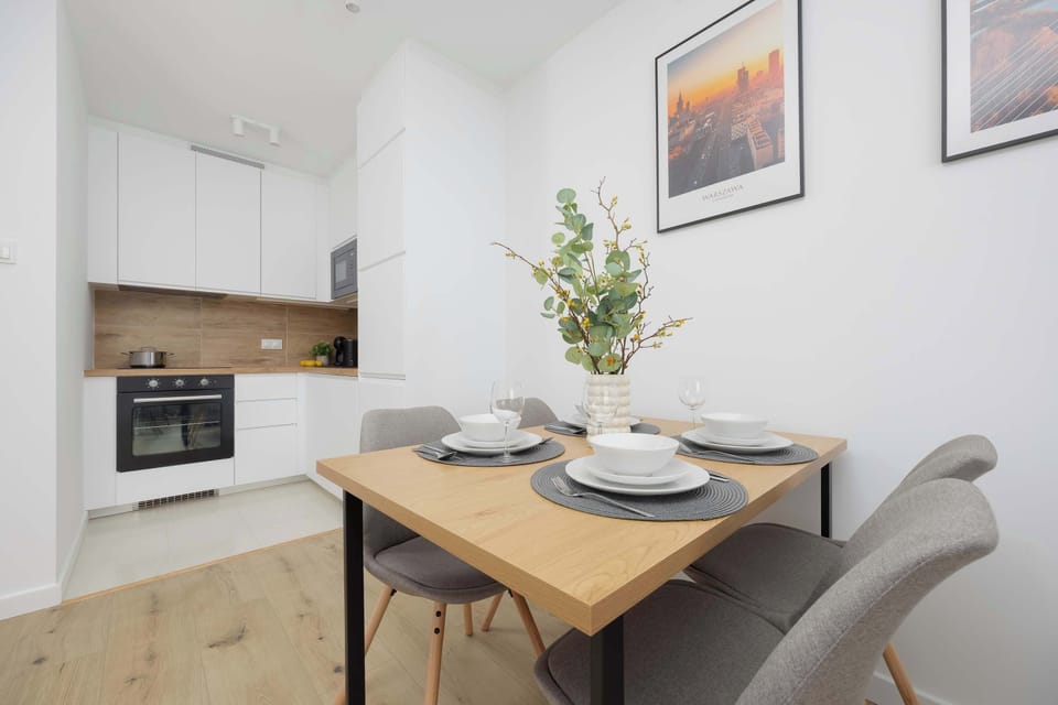 The elegantly set table in the kitchenette creates a perfect space for shared meals, with natural light enhancing the cozy ambiance.