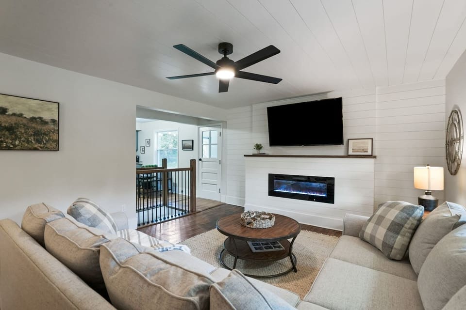 Unwind in this cozy living room with a plush sectional, rustic coffee table, and modern fireplace beneath a large flat screen TV. It’s the perfect spot for relaxing evenings or movie nights with loved ones.