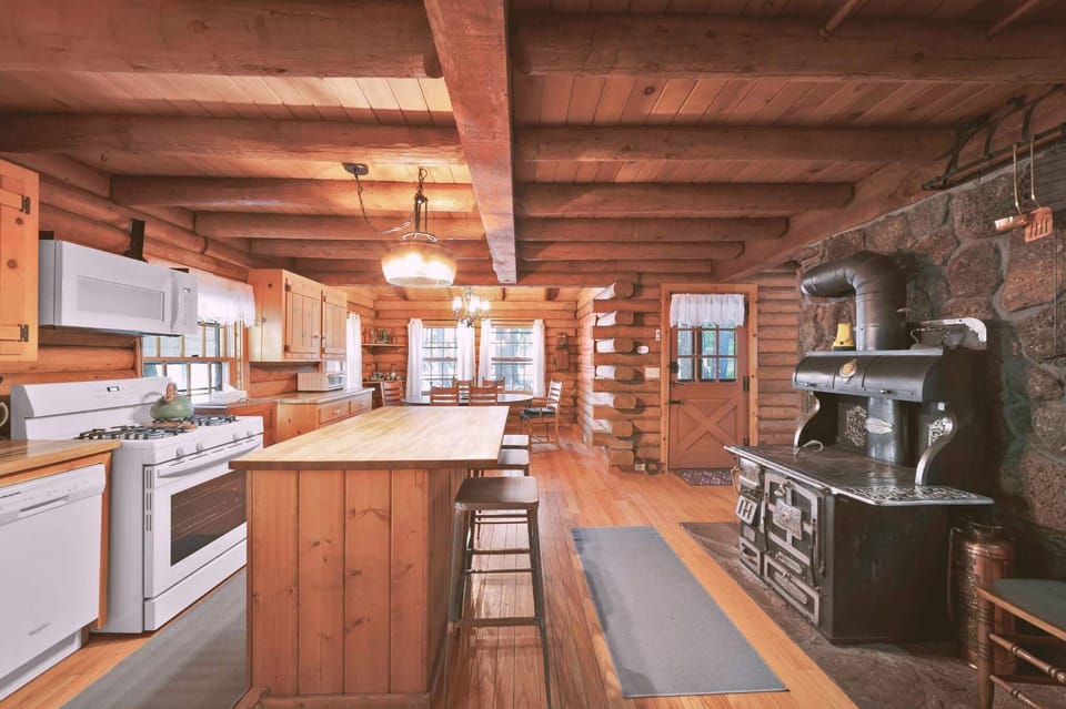 The fully equipped kitchen features a gas stove, microwave, dishwasher, and plenty of counter space for meal prep—including a large center island with barstool seating, perfect for breakfast or casual conversations over coffee. 