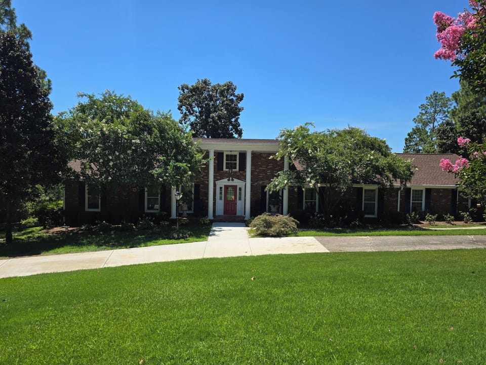 Front of house with semi-circle driveway.