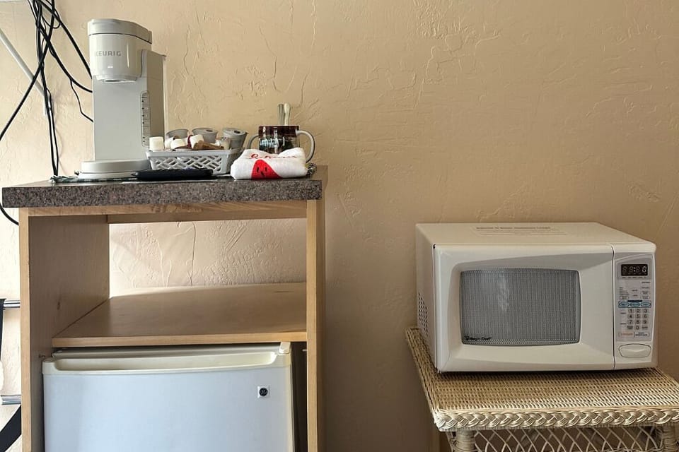 The room features a mini fridge, microwave and Keurig.