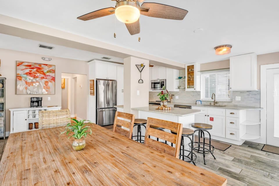 This open-concept kitchen flows seamlessly into the dining and living areas, with large windows framing ocean views for a relaxed and scenic culinary experience.
