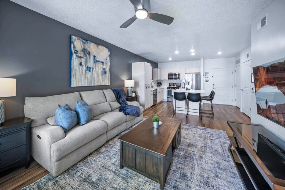 Beautifully designed living room. 65` TV, leather sofa and amazing views of mountains and city skyline.