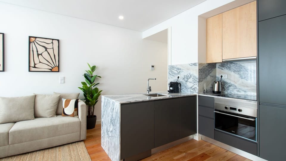 Contemporary kitchenette with sleek marble finishes, fully equipped for all your culinary needs. #modernliving #stylishkitchen #portoapartment