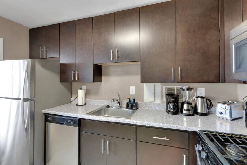 Coffee maker, blender, toaster, and kettle lined up and ready to go — mornings start fast and dinner prep runs smooth in this fully equipped kitchen.