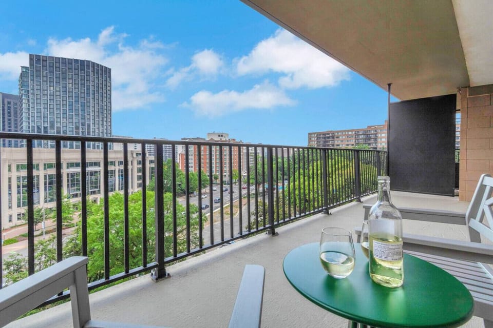 Private balcony with table, chairs, and sweeping National Landing skyline views — start your day with coffee or end it with a glass of wine up here.