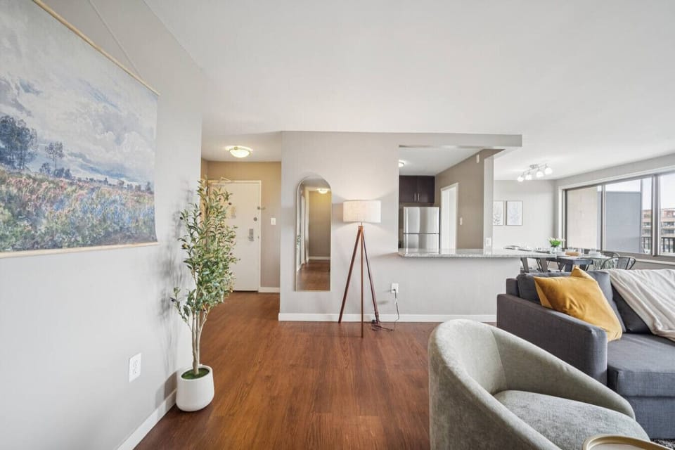 Step through the door and the entire layout unfolds — mirrored foyer, open kitchen, and a sunlit living room that makes you exhale on arrival.