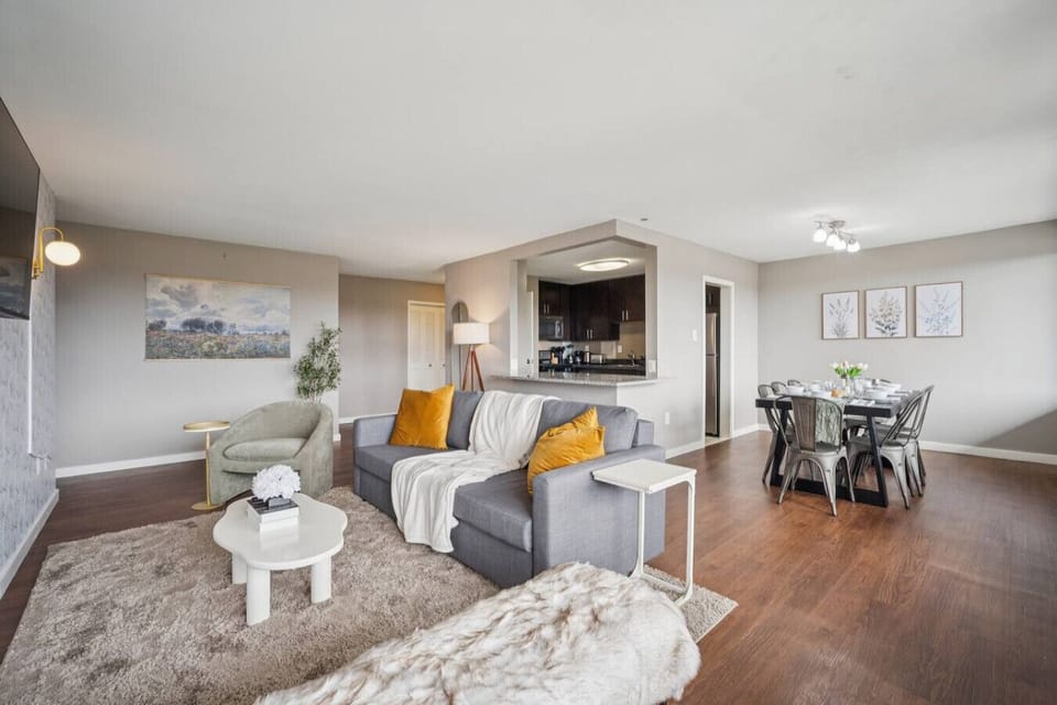 Open sightlines connect the lounge, dining table, and kitchen pass-through — everyone stays part of the conversation no matter where they land.
