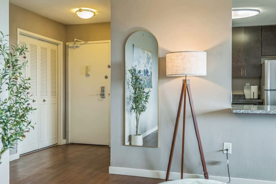 Arched mirror and designer lamp in the entryway — a polished first impression that doubles as a quick-check spot before heading out.
