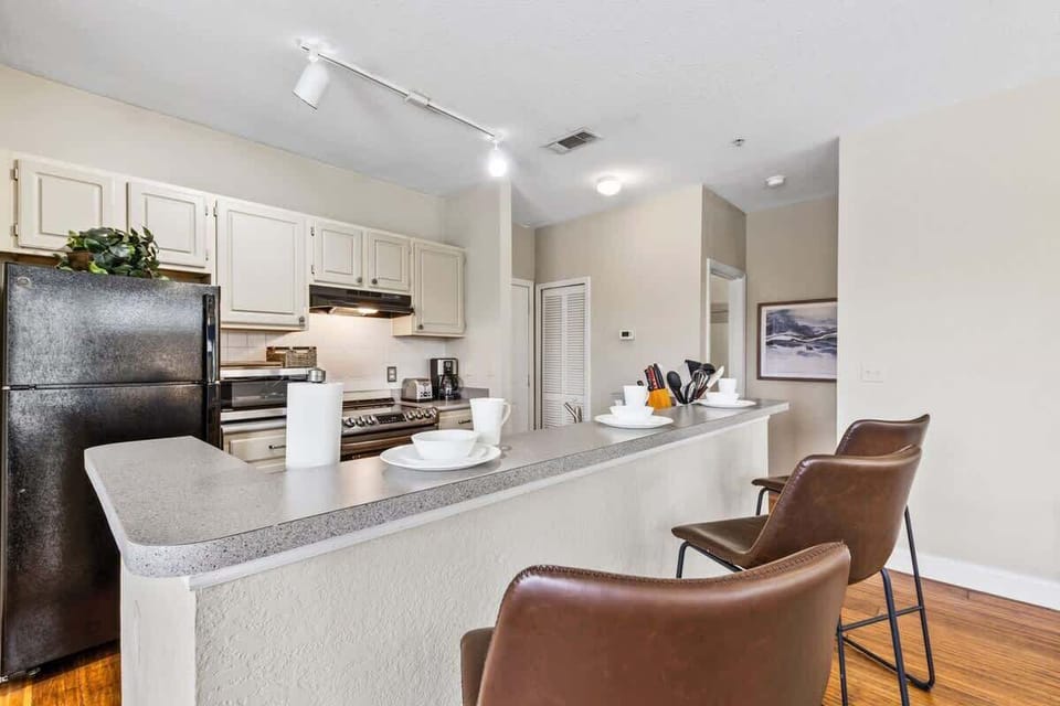 - Cook in this fully equipped kitchen with modern appliances & a spacious bar
- Enjoy meals at the stylish counter with barstool seating, perfect for casual dining
- Bright, open, & stocked with essentials, everything you need for a hassle free stay