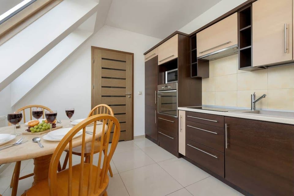 Kitchenette with a spacious layout, wooden dining table and stylish chairs – ideal for quick meals.