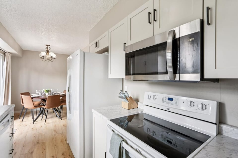 Compact kitchen with stove, microwave, and dining view