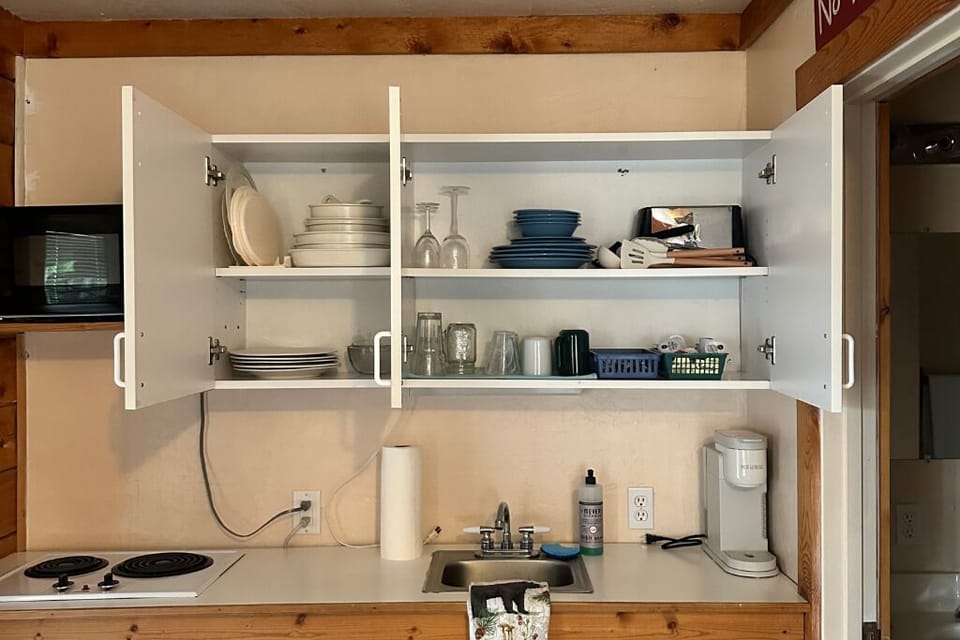The kitchenette also holds dinnerware, cookware, a toaster, and utensils.  