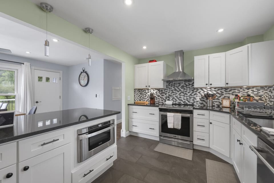 Modern kitchen with sleek countertops, built-in microwave, and pendant lighting.