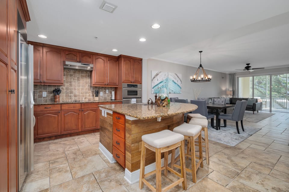Wood cabinetry adds warmth to this modern kitchen space. It’s perfect for anything from breakfast to business lunches.