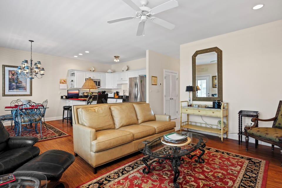 Relax in your elegant open-plan living space, where rich hardwood floors and a cozy leather sofa create the perfect atmosphere for unwinding.