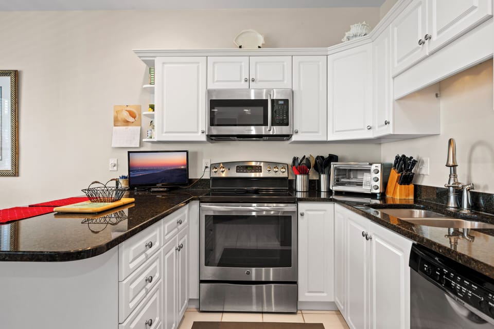 Your fully equipped kitchen features granite countertops and stainless steel appliances, perfect for cooking meals together during your stay.