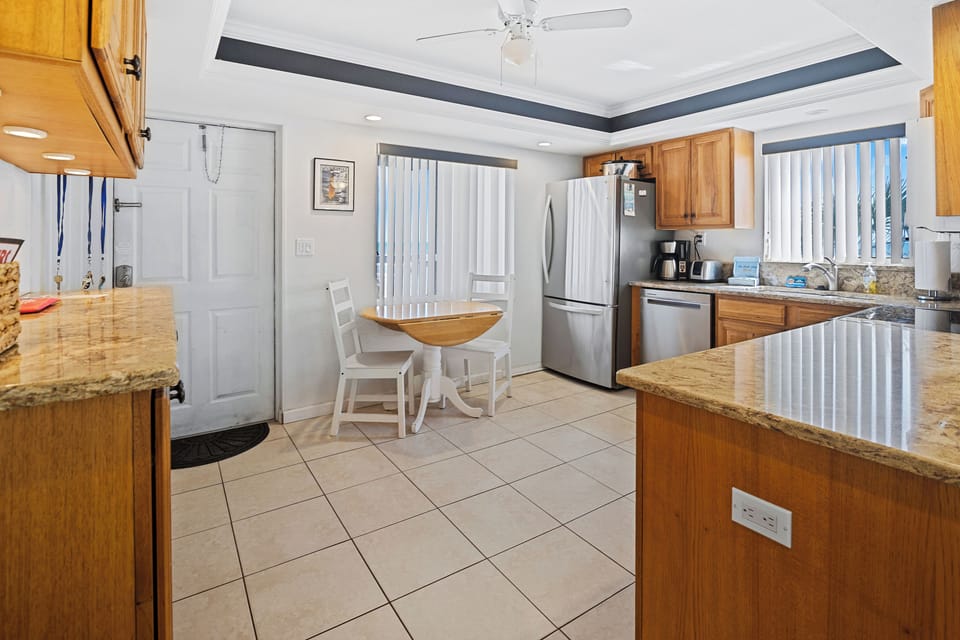 Spacious kitchen with granite countertops, stainless steel appliances, and a cozy dining nook. Perfect for enjoying meals before or after a relaxing beach day at your coastal getaway.